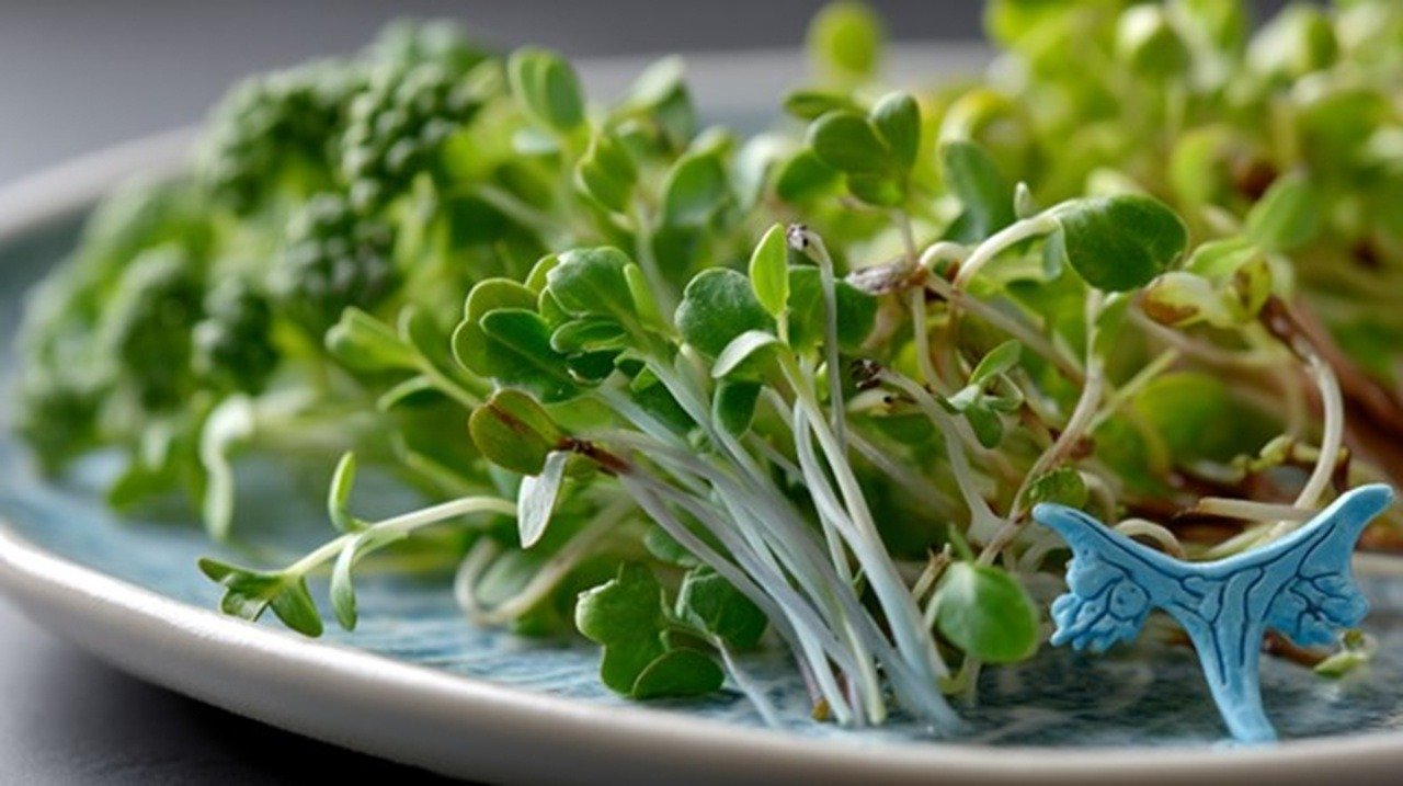 A close-up of vibrant cruciferous microgreens—broccoli, kale, and radish sprouts—arranged beside a medical illustration of the human thyroid gland. The microgreens display delicate stems and tiny emerald leaves against a white ceramic plate.